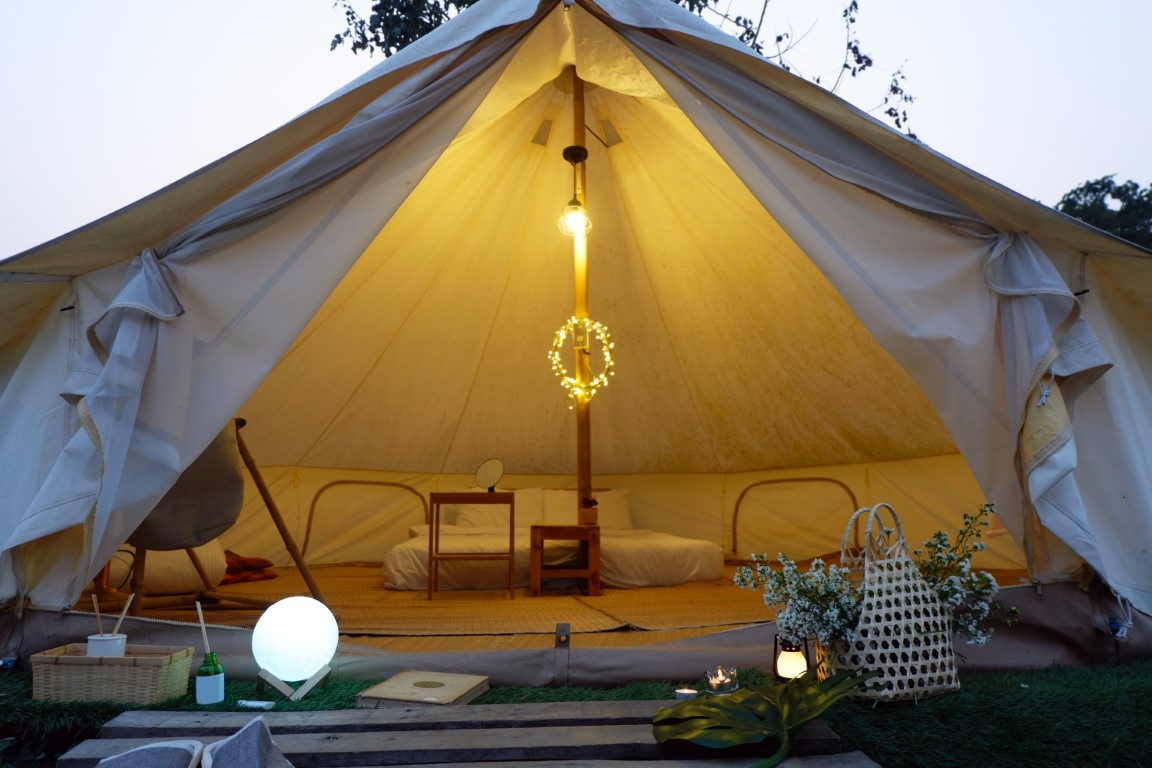 Bell Tents in nature background. Stretch tent at wedding with pool in foreground